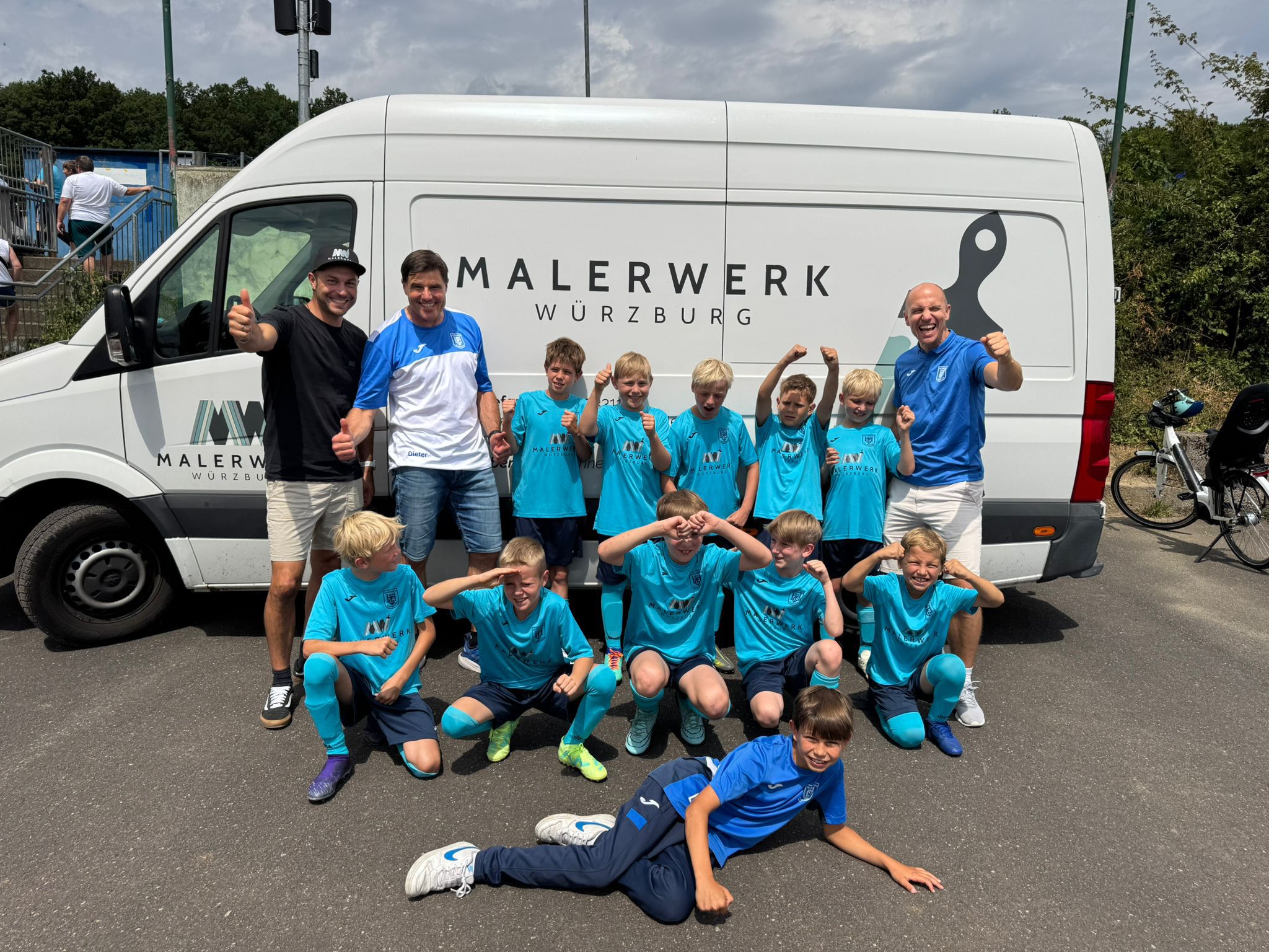René Hennenberg von Malerwerk Würzburg übergibt Trikots an die U11 blau der TG Höchberg